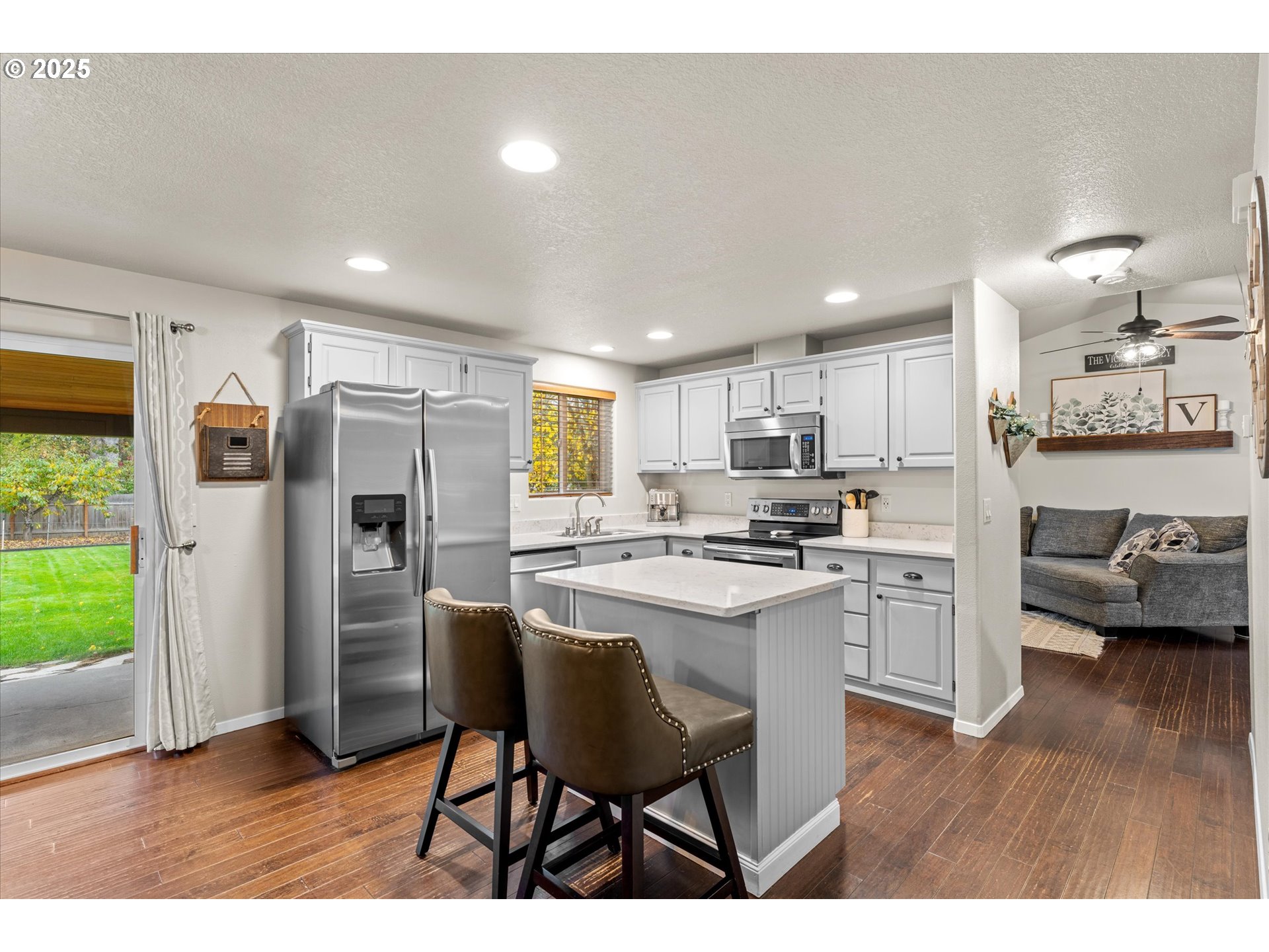 3019 Brooke Street Forest Grove, OR 97116 - Photo 2 of 34 a open kitchen with stainless steel appliances kitchen island granite countertop a refrigerator a stove a sink a dining table and chairs
