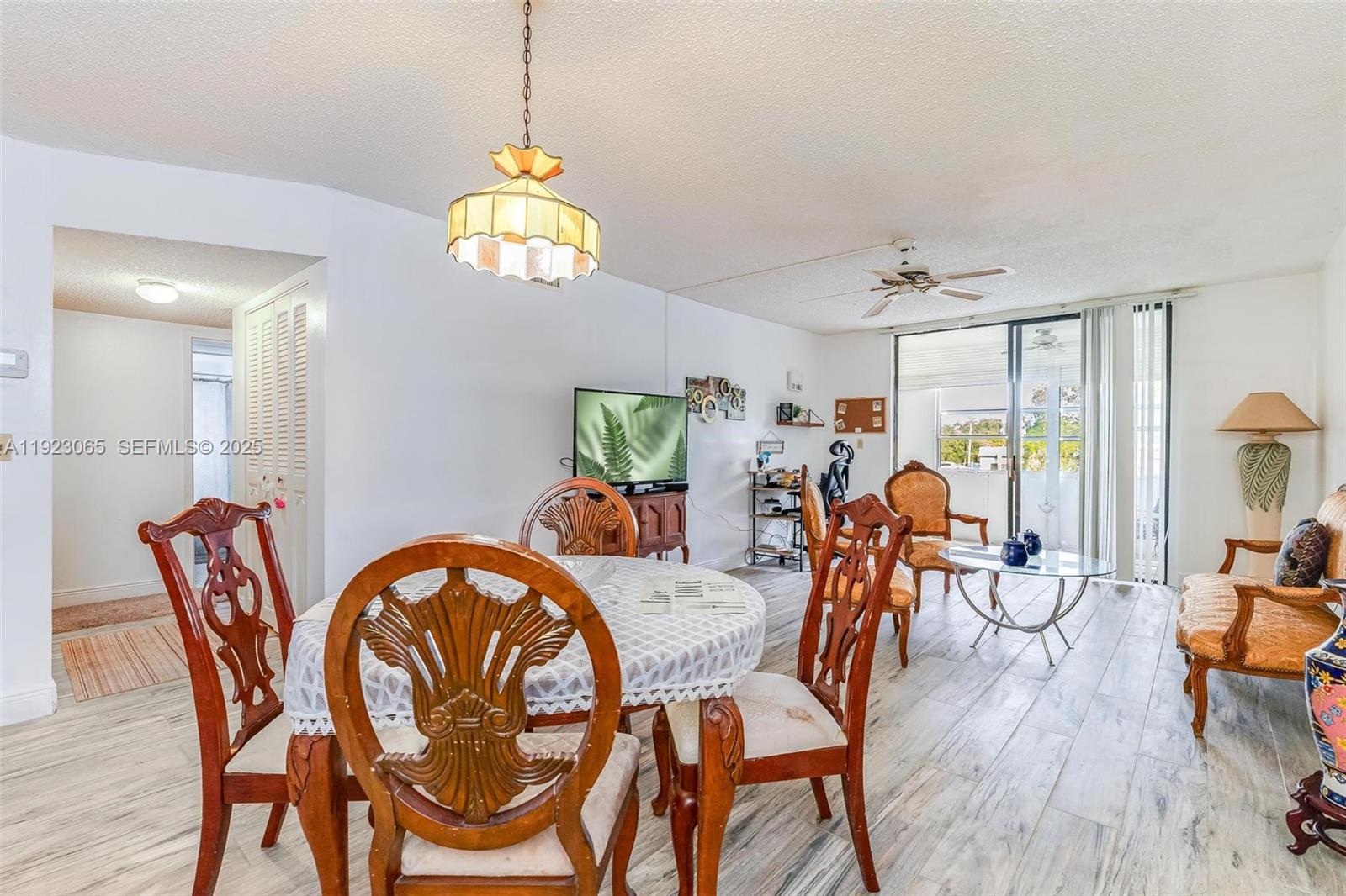 2840 Somerset Drive, Unit 207M Lauderdale Lakes, FL 33311 - Photo 15 of 25 a dining room with furniture a chandelier and wooden floor