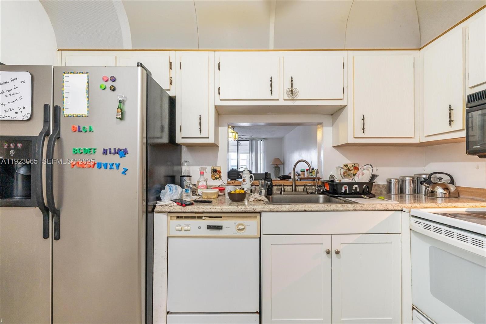 2840 Somerset Drive, Unit 207M Lauderdale Lakes, FL 33311 - Photo 6 of 25 a kitchen with refrigerator and cabinets