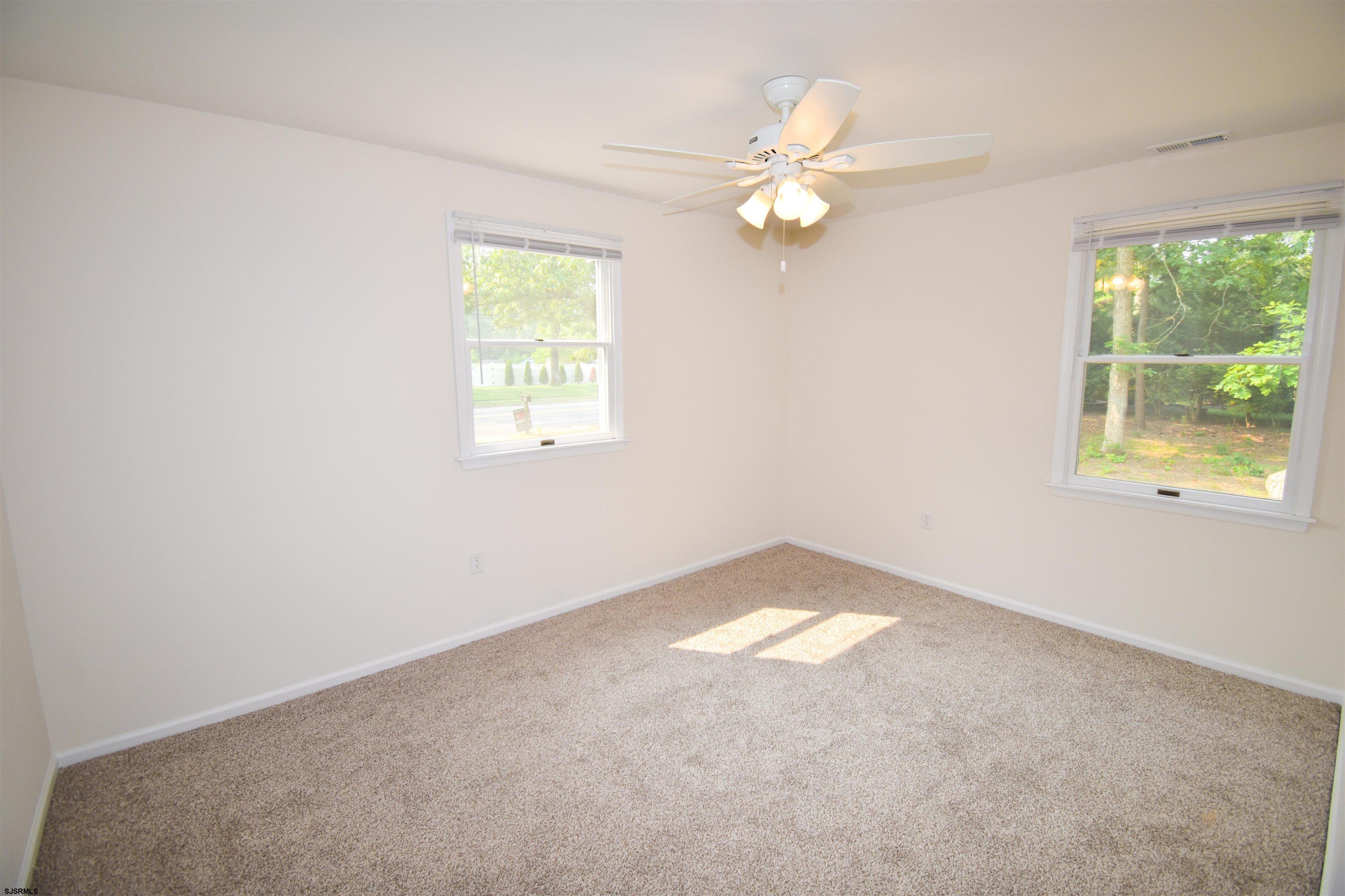 600 Stagecoach Road Marmora, NJ 08223 - Photo 13 of 29 an empty room with windows and chandelier fan