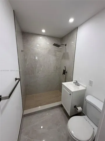 a bathroom with a sink mirror vanity and toilet