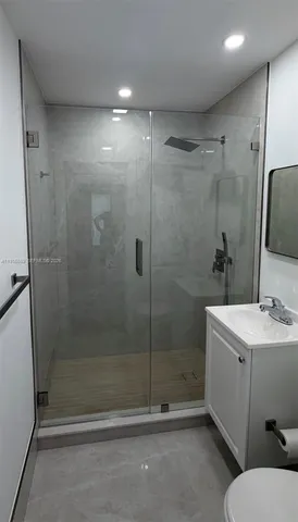 a bathroom with a shower a sink a toilet and a mirror