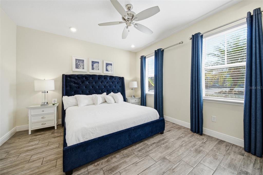 8017 Surf Street Kissimmee, FL 34747 - Photo 24 of 64 a bedroom with a large bed and a chandelier