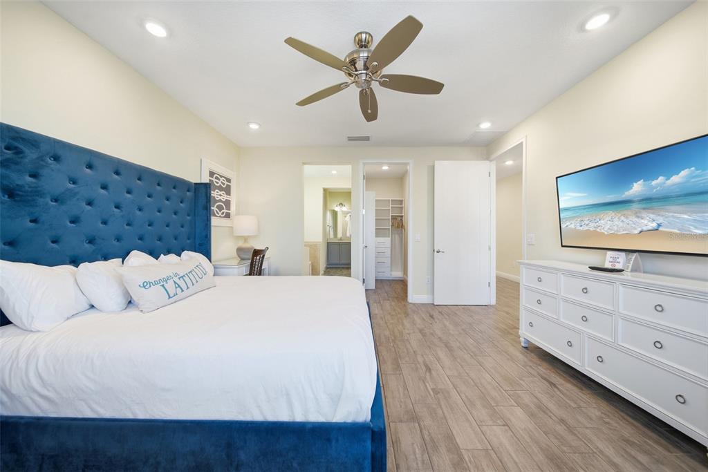 8017 Surf Street Kissimmee, FL 34747 - Photo 36 of 64 a spacious bedroom with a bed and a flat screen tv