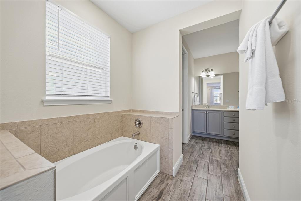 8017 Surf Street Kissimmee, FL 34747 - Photo 38 of 64 a bathroom with a tub sink and mirror