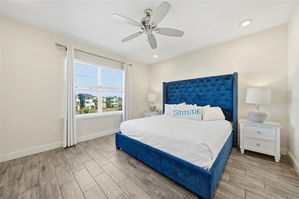 8017 Surf Street Kissimmee, FL 34747 - Photo 44 of 64 a spacious bedroom with a bed and a table