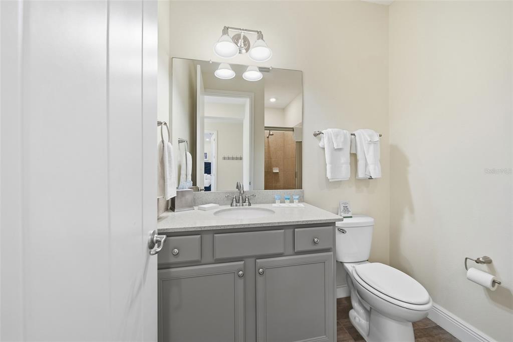 8017 Surf Street Kissimmee, FL 34747 - Photo 7 of 64 a bathroom with a toilet a sink a mirror and vanity