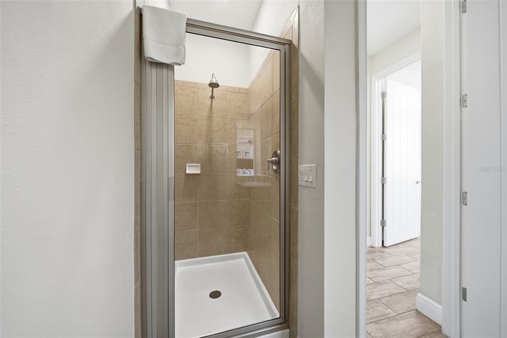 8017 Surf Street Kissimmee, FL 34747 - Photo 8 of 64 a bathroom with a glass shower door