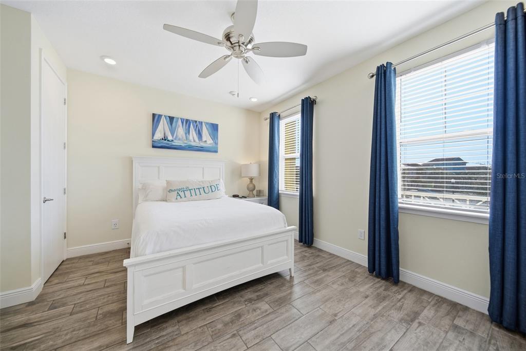 8017 Surf Street Kissimmee, FL 34747 - Photo 10 of 64 a bedroom with a large bed chandelier and a window