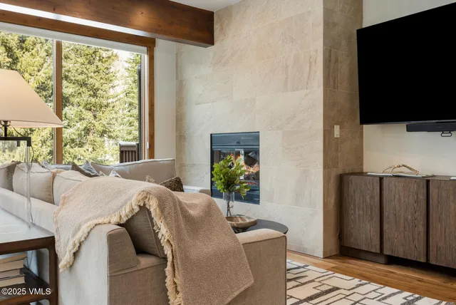 a living room with furniture a flat screen tv and a window