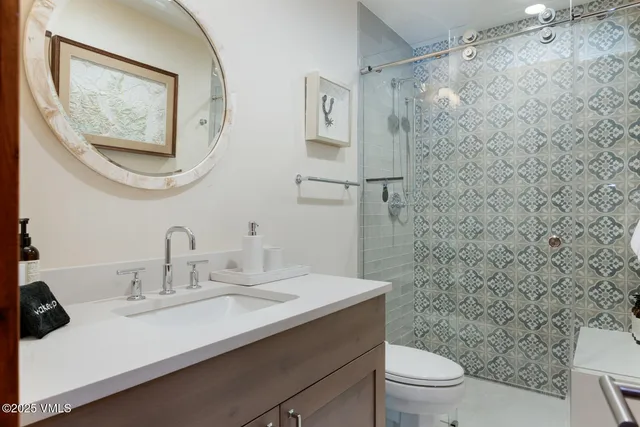 a bathroom with a sink mirror and toilet