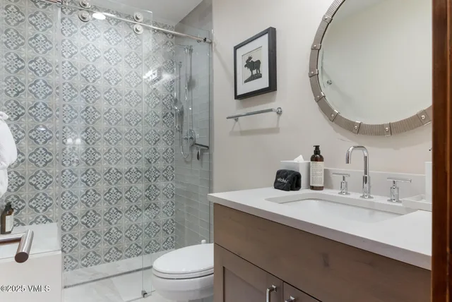 a bathroom with a sink a toilet and a mirror
