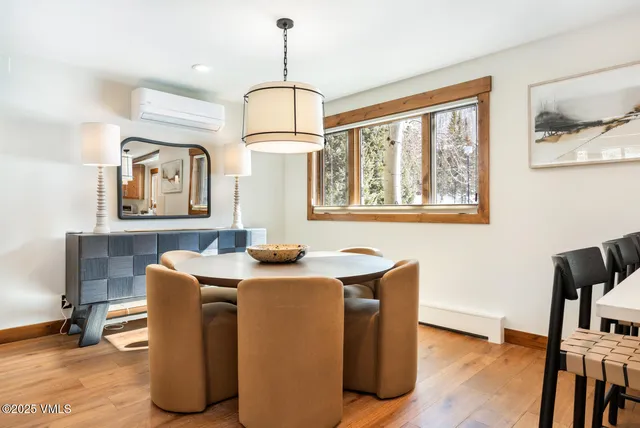 a dining room with furniture a window and wooden floor