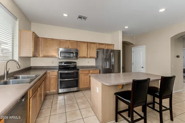 a kitchen with kitchen island a refrigerator stove microwave and cabinets