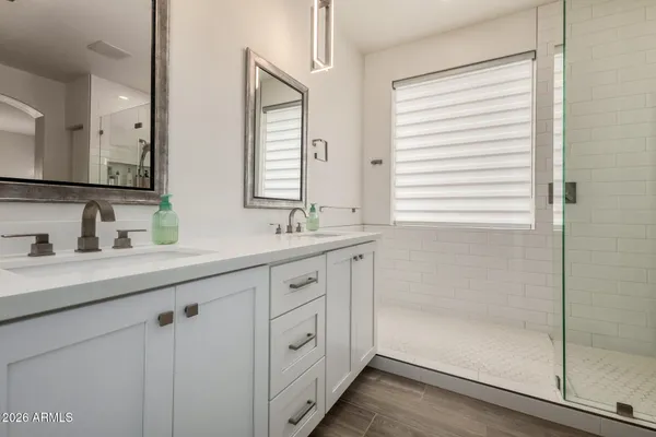 a bathroom with double sink and a mirror