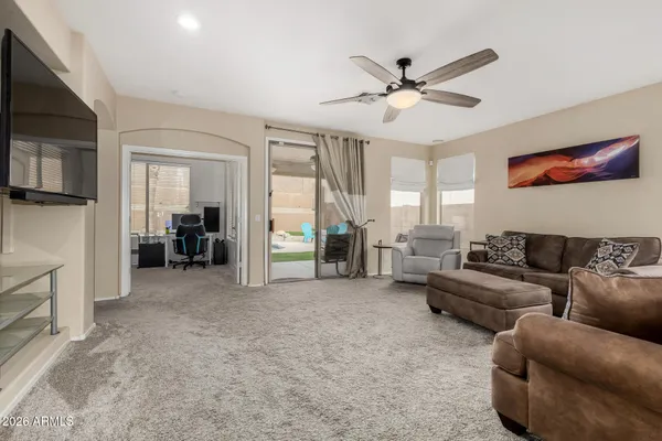 a living room with furniture and a ceiling fan