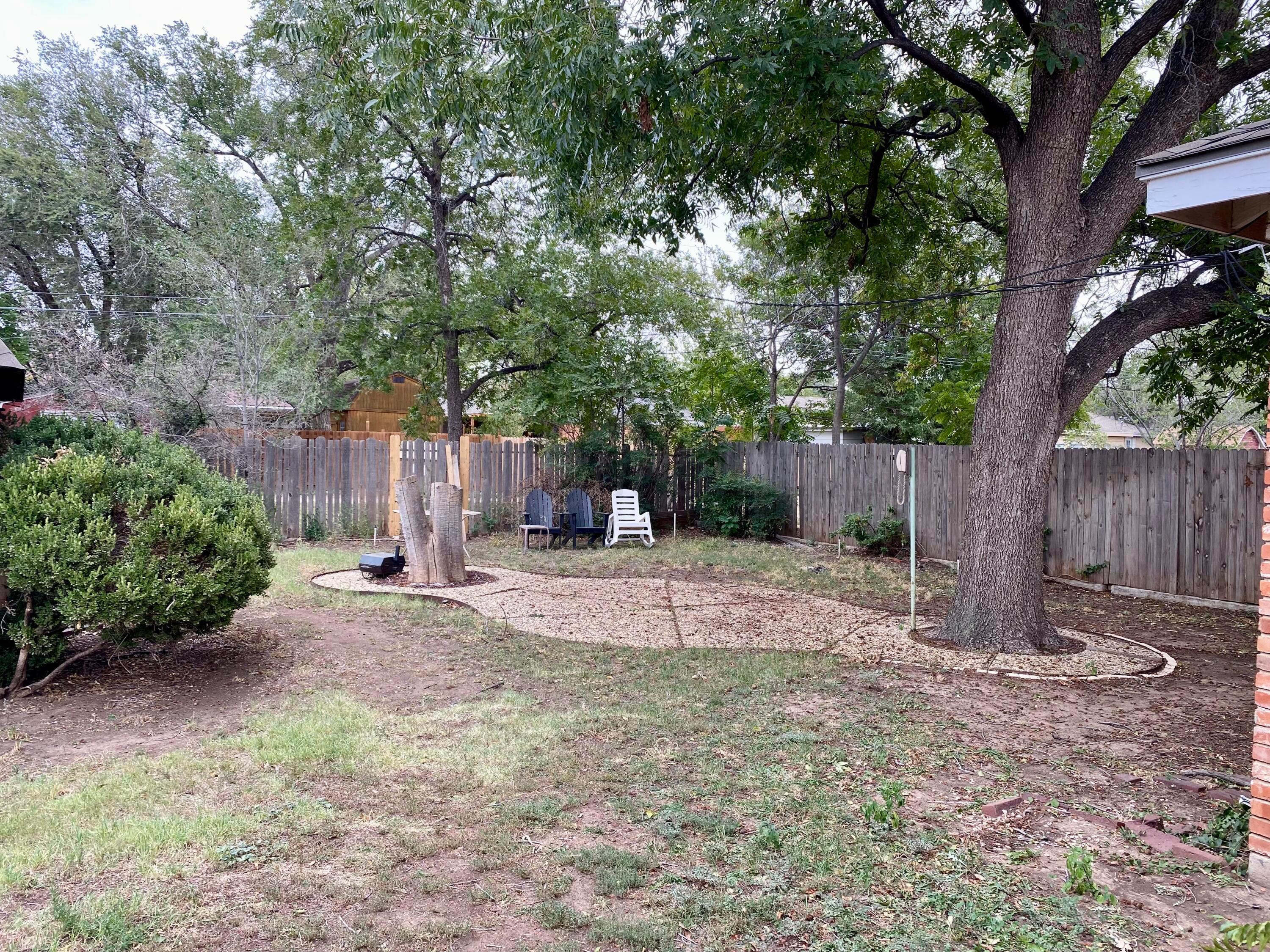 3309 Paramount Boulevard Amarillo, TX 79109 - Photo 22 of 26 a backyard of a house with a tree and wooden fence