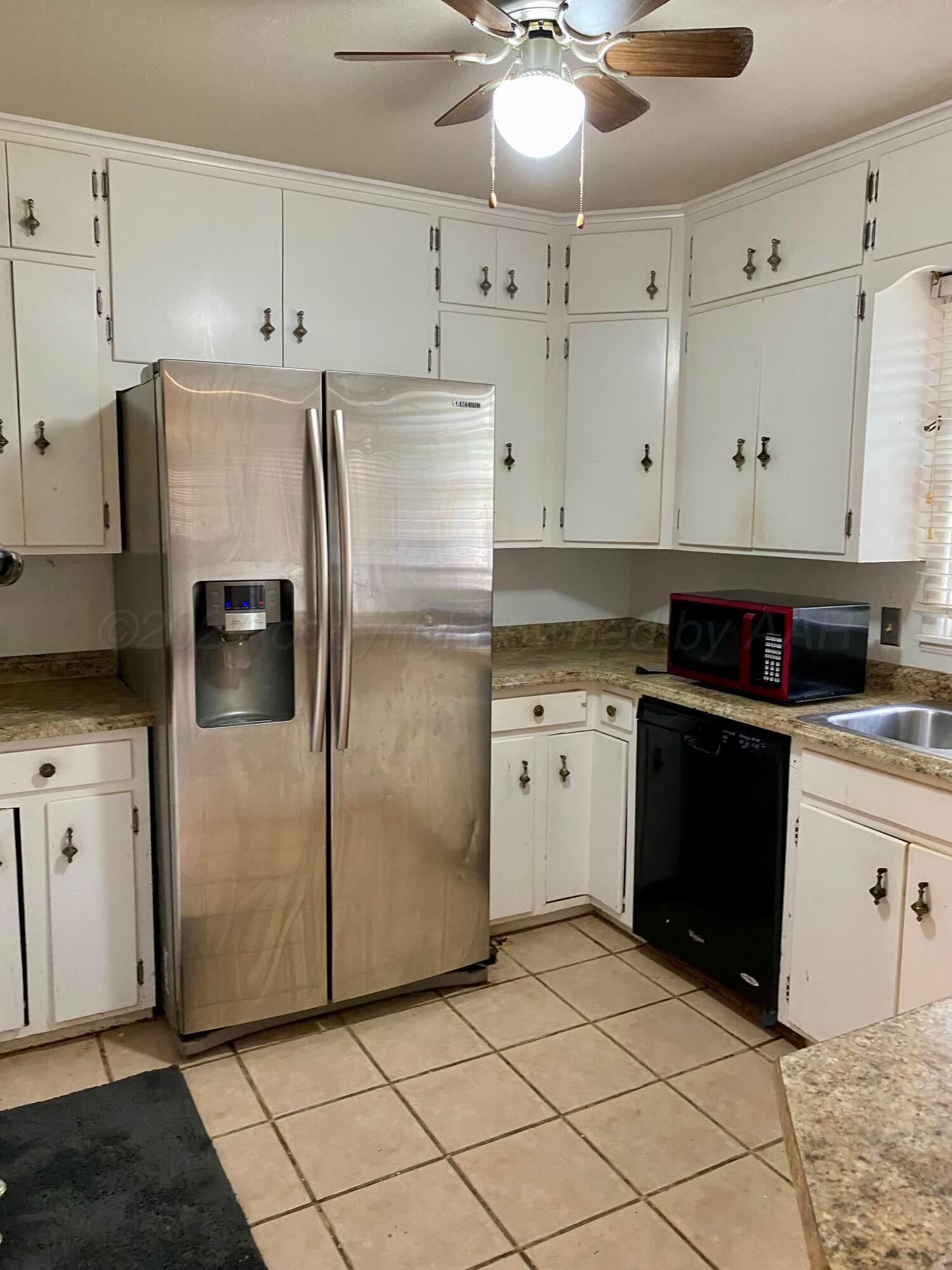 3309 Paramount Boulevard Amarillo, TX 79109 - Photo 6 of 26 a kitchen with granite countertop cabinets and refrigerator
