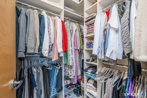 a view of walk in closet with clothes