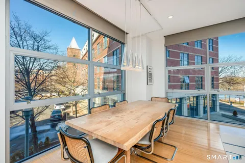 a view of a dining room with furniture large windows and wooden floor