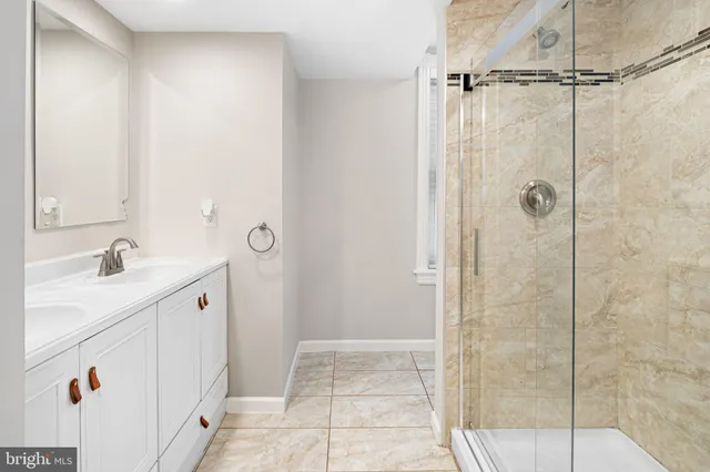a bathroom with a granite countertop sink a shower and a mirror