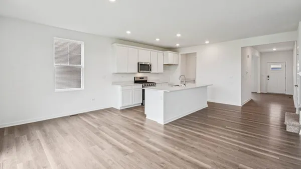 a view of kitchen with wooden floor and electronic appliances