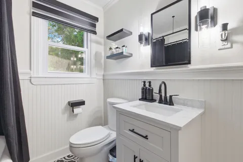 a bathroom with a sink a toilet and a mirror