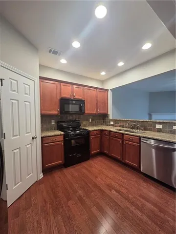 a kitchen with granite countertop a stove and cabinets