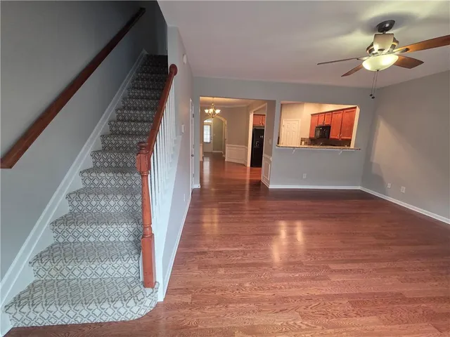 a view of an empty room with wooden floor fireplace and a window