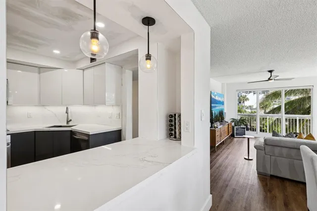 a large kitchen with kitchen island a large counter top space a sink stainless steel appliances and cabinets