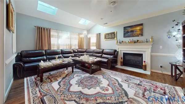 an empty room with wooden floor fireplace and windows