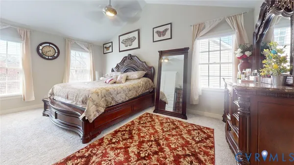 a spacious bedroom with a bed and a flat screen tv