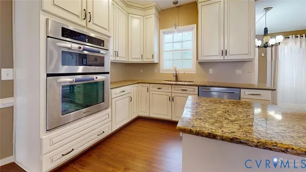a large kitchen with stainless steel appliances granite countertop a stove a sink and a granite counter tops