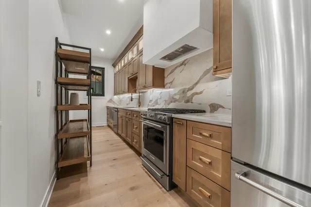 a kitchen with stainless steel appliances granite countertop a stove and a refrigerator