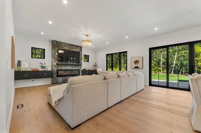 a living room with furniture large window and flat screen tv