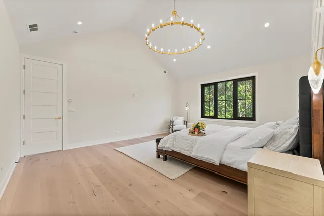 a bedroom with a bed and a chandelier