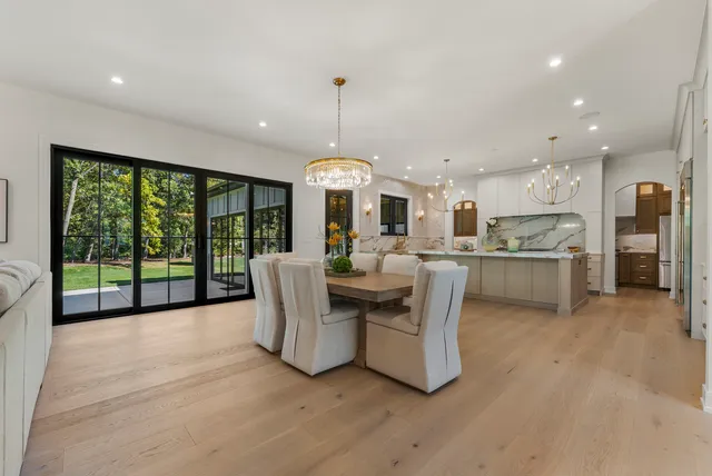 a living room with stainless steel appliances granite countertop furniture a fireplace a flat screen tv and a large window