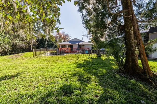 a view of a house with a big yard and large trees