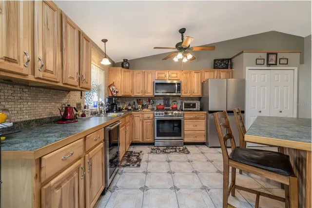 a kitchen with granite countertop a stove a sink dishwasher a refrigerator and cabinets with wooden floor