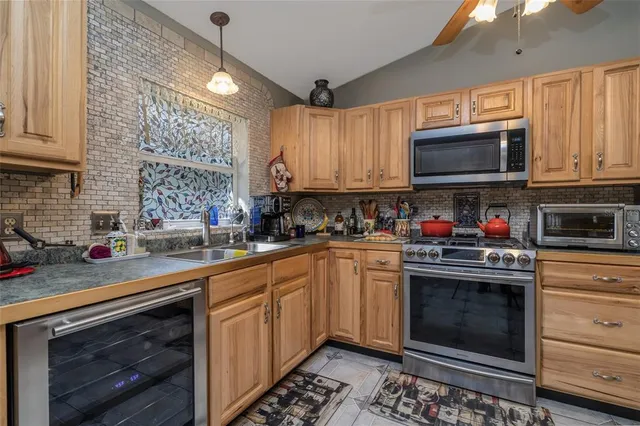 a kitchen with stainless steel appliances granite countertop a stove sink microwave and cabinets