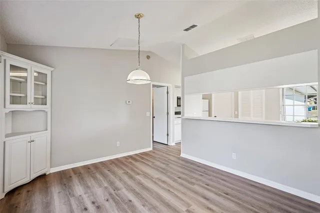 a view of empty room with wooden floor and window
