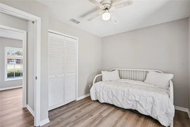 a living room with a bed furniture and wooden floor
