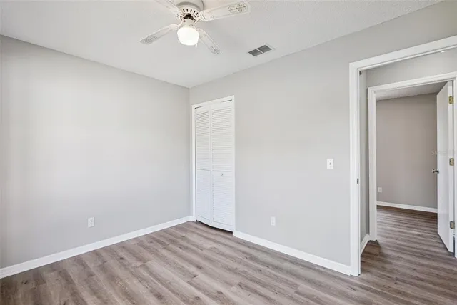 a view of an empty room with wooden floor
