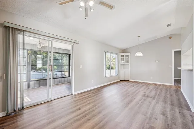 a view of an empty room with a window and wooden floor
