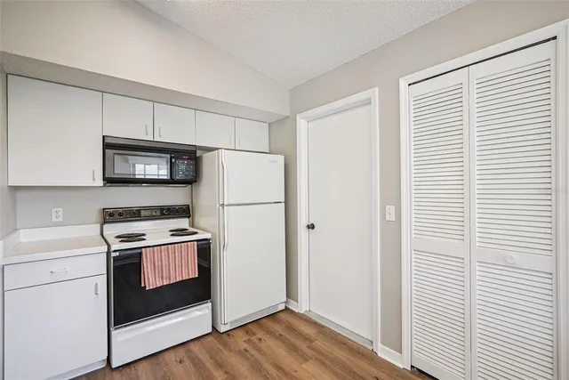 a kitchen with a refrigerator stove and white cabinets
