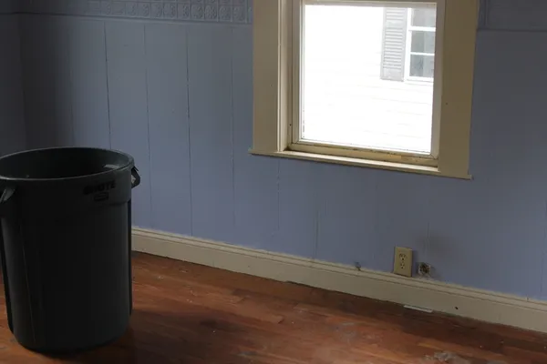 a view of a small space with wooden floor and a window
