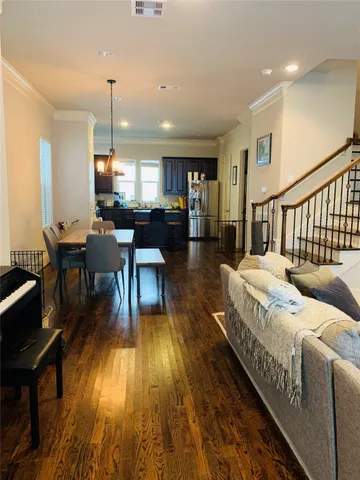 a living room with couches a dining table with wooden floor