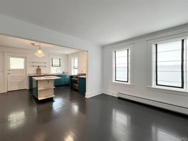 a kitchen with kitchen island granite countertop a sink cabinets and wooden floor