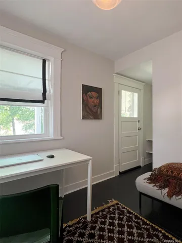an empty room with wooden floor and a window