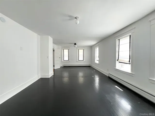 a view of a hallway with wooden floor and closet
